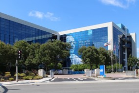 Enseigne Intel lumineuse sur la façade d'un bâtiment d'entreprise, évoquant les investissements massifs dans les semi-conducteurs et l'IA